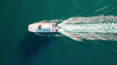 Denize açılmak. Yat üstü manzarası. Sürat teknesi denizde yüzüyor. Yat limanına giden tekne. Yelkencilik ve yat turizmi. Lüks bir yaşam tarzı. Yaz tatili. Havadan açık deniz botu. Mavi su navigasyonu.