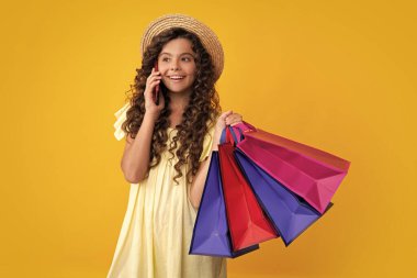 Stylish teen girl with shopping sale bags. Kid holding purchases. Happy teenager, positive and smiling emotions of teen girl