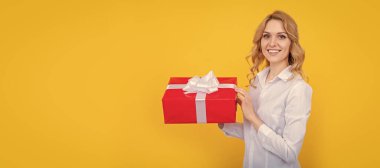 happy woman hold big present box on yellow background. Woman isolated face portrait, banner with mock up copy space