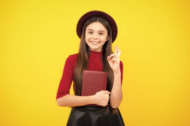Happy teenager portrait. School child with book. Learning and education. Smiling schoolgirl