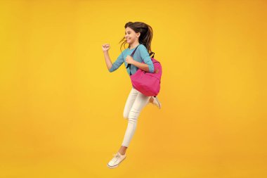 Sırt çantalı liseli kız. Tecrit edilmiş genç bir öğrenci. Öğrenme ve bilgi. Git çalış. Koş ve atla. Çocuk eğitimi konsepti. Mutlu ergen portresi. Gülümseyen kız