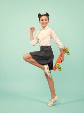 Modayı takip eden genç modelin gündelik görüntüsü. Genç yeniyetme hippi şehir hayatı. Sokak tarzı hippi elbiseli, kaykaylı bir kız çocuğu.