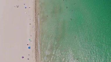 Deniz, plaj şemsiyesi altında rahatlar. Denize açılın. Kristal berrak turkuaz suyla kumsalın havadan görünüşü. Kumsalın tadını çıkarıyorum. Cennette yaz tatili. Yazın deniz kenarında tatil..