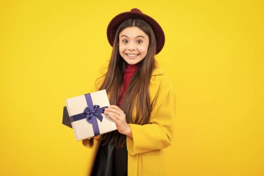 Mutlu genç sonbahar portresi. Mutlu kız yüzü, pozitif ve gülümseyen duygular. Hediye kutusu olan ergen bir çocuk. Genç kız doğum günü hediyesi veriyor. Hediye, selam ve hediye konsepti. Gülümseyen kız