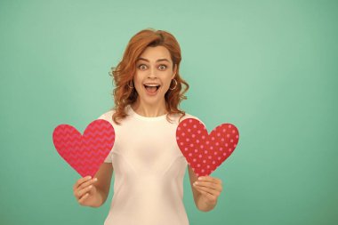 happy surprised young girl with red heart on blue background.