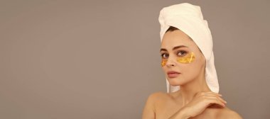 Eye patches, patch under eyes. Beautiful woman isolated face portrait, banner with mock up copy space. the best care. young woman in terry towel use patch. beauty day in spa