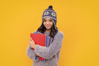 Sırt çantası ve uyarı şapkası olan, izole edilmiş sarı bir geçmişi olan liseli kız öğrenci. Öğrenme ve bilgi eğitimi kavramı. Mutlu yüz, pozitif ve gülümseyen genç kız duyguları