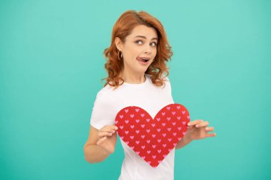 Mavi arka planda kırmızı kalpli genç bir kadın..