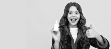 cheerful teen girl with curly hair in comfortable pajama use nasal drops, runny nose. Horizontal poster of isolated child face, banner header, copy space