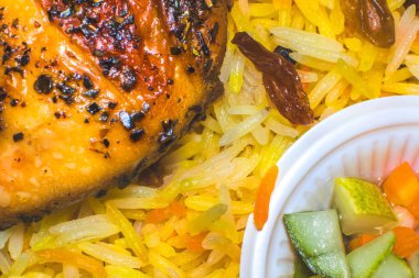 Kızarmış tavuk, kuru üzüm ve sebzeyle servis edilen Makro pilav fotoğrafı. 