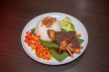 Siyah soslu ördek yemeği ve sıcak pirinçle servis edilen kırmızı biber sosu. Beyaz tabakta servis edilen kırmızı biber soslu 