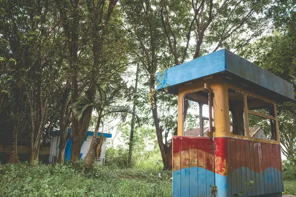 stock image Abandoned old building with overgrown grass surrounding. Abandoned parking booth building.