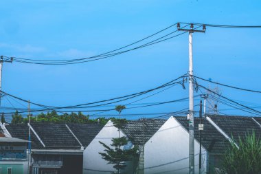 Endonezya 'da çatı kiremit ve elektrik direği elementli sıra ev fotoğrafları. Çatı kiremidi. Açık gökyüzünde fotoğraf.