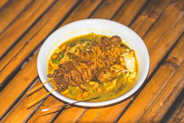 Eşsiz yemeklerle servis edilen tavuk lapası kasesi. Geleneksel tavuk lapası ve tavuk bağırsağı satay yemekleri. Endonezya 'dan özgün bir geleneksel. Endonezya 'dan geleneksel yemeklerin Macro fotoğrafı.