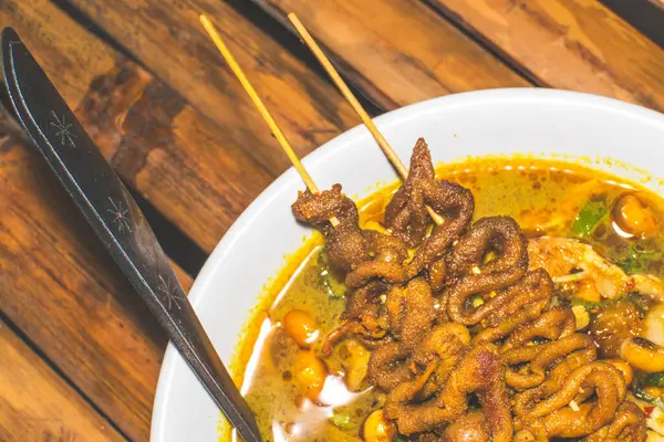 stock image Chicken porridge bowl served with unique dishes. Traditional chicken porridge with chicken intestine satay dishes, authentic traditional from Indonesia. Macro photo of traditional food from Indonesia.