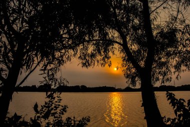 Gölde alacakaranlıkta siluet fotoğrafı. Alacakaranlıkta gölün kenarında bir an