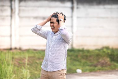 Gençler hayal kırıklığı içinde bağırıyor. Kafasını tutarken hayal kırıklığına uğramış ve avazı çıktığı kadar bağırıyordu.