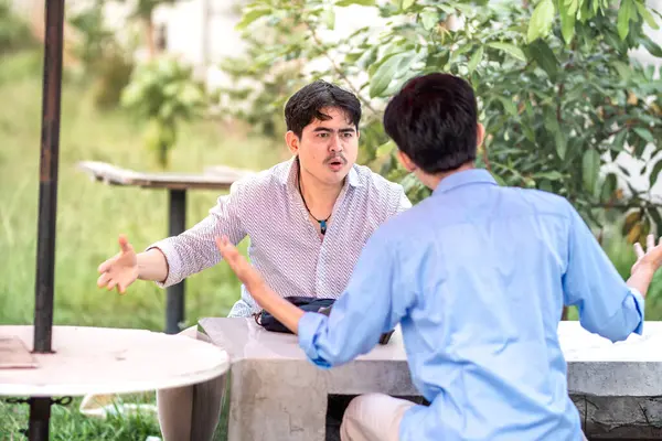 stock image Two men arguing each other in the park. 2 men debate with each other, blame each other