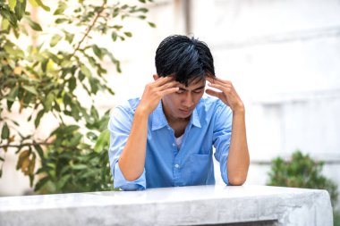 Young men in depression sitting alone in the park. Depressed and frustrated young men full of problems clipart