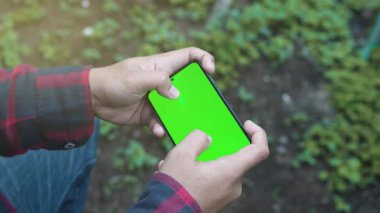 Yeşil Ekran ile Akıllı Telefon 'da Mobil Oyun Oynayan Oyuncu. Adam Tutan Akıllı Telefon Oyun Oyunu