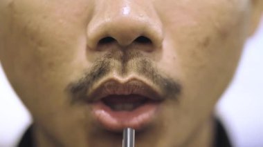 Pipetle İçen Adam 'ın Yakın Çekimi. Kamıştan yudumlanan Erkek Dudakları Macro shot 'ı