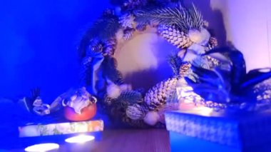 Yeni yıl aksesuarları, Noel Baba heykelciği, parlak renkli çelenk, mavi şerit. Noel çelenkleri el yapımı atmosfer şenlikli bir akşam, yeni yıl arifesi natürmort.