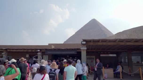エジプトのギザ 2022年12月 多くの観光客が彼らのチケットを購入し エジプトのピラミッドの領域に入るのを待ちます 背景にはギザの大ピラミッドの一部です — ストック動画