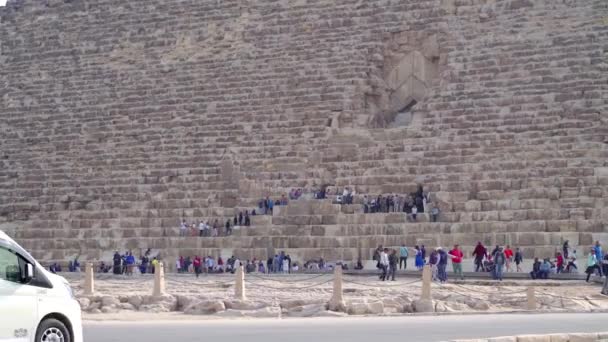 2022年12月 吉萨金字塔的一部分景观 在背景下 有些人进入入口 前面有几辆车经过 — 图库视频影像