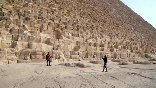 エジプトのギザ 2022年12月 2人の友人はギザの大ピラミッドの前で写真を撮る これらのピラミッドは世界の七不思議の一つと考えられています — ストック動画