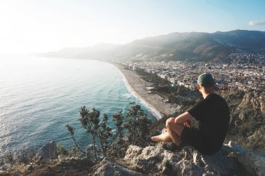 Bir plaj ve şehir silueti üzerindeki manzara noktasında sporcu - Alanya (Türkiye).