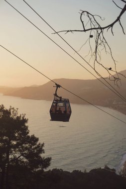 Gün batımında kıyı şeridi manzaralı kablo araba.