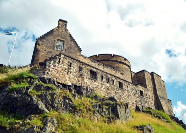 Tarihi bina, Edinburgh Kalesi, İskoç bayrağı rüzgarda dalgalanırken aşağıdan çekildi.