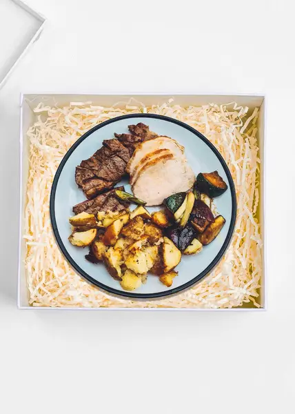 Play on the meal in a box idea, plated roast dinner on a bed of shredded paper in a box