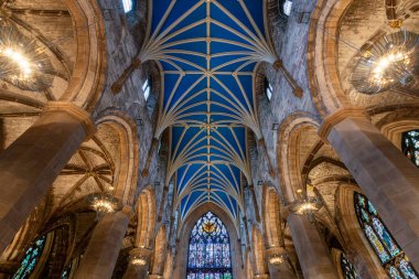 Edinburgh, İskoçya - 20 Kasım 2017: Edinburgh Katedrali 'nin görkemli iç mekanı, koyu mavi arka planda altın yıldızlarla süslenmiş, karmaşık kurdeleli kemerler ve süslü avizeler.