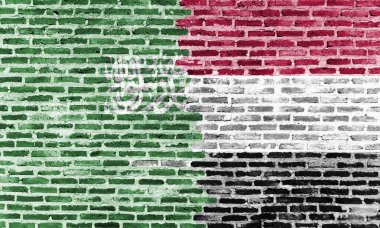 Tuğla bir duvara yapıştırılan Suudi Arabistan ve Yemen bayrakları, bölgesel bağları, çatışmaları veya kültürel bağlantıları simgeliyor