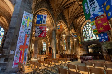 Edinburgh, İskoçya - 20 Kasım 2017: Edinburgh Katedrali 'nin içinde karmaşık taş işçiliği, renkli asılı pankartlar, ahşap koltuklar ve boyalı cam pencereler yer almaktadır.