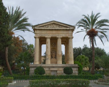 Aşağı Barrakka Bahçeleri, Valletta, Malta 'daki Sir Alexander Ball' un Neoklasik Anıtı. Palmiye ağaçları ve dingin bir park ortamındaki yemyeşil çimlerle çevrili.