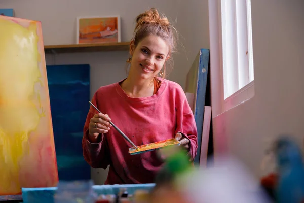 stock image Portrait of caucasian female painter sitting by the window of her studio looking into camera