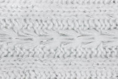 Beyaz örülmüş yün süveterin desenli arka planı.