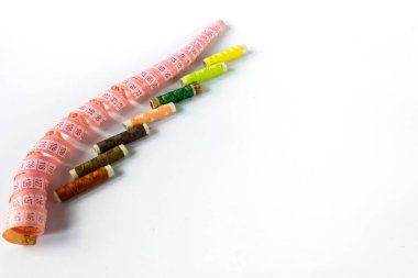 Beyaz arka planda çok renkli iplikler ve bobinler. Metin için boşluk. İğne işi konsepti.