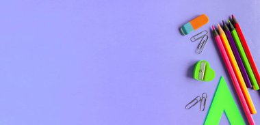 Okul malzemeleri menekşe arka planda. Metin için boşluk.