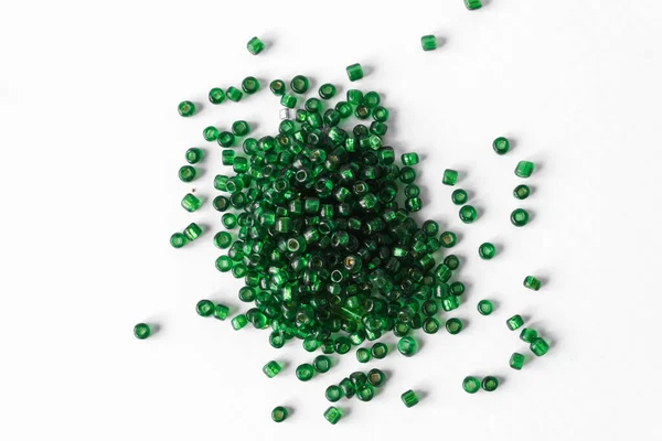 stock image Scattered pile of green beads on a white background. Top view.