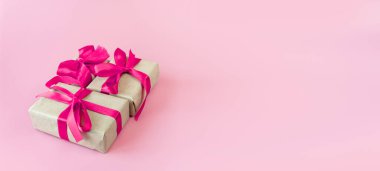 Pembe arka planda kurdeleli hediye kutuları ve mesaj için yer. Boşluğu kopyala.