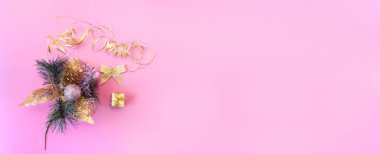 Pembe arka planda noel ve yeni yıl düzeni. İçinde köknar dalı ve oyuncaklar olan bir kartpostal. Pankart. Üst Manzara. Düz yatıyordu. Boşluğu kopyala.