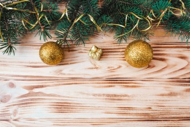 Ahşap bir arka planda Noel ve Yeni Yıl düzeni. İçinde köknar dalı ve oyuncaklar olan bir kartpostal. Yukarıdan bak. Düz yatıyordu. Boşluğu kopyala.