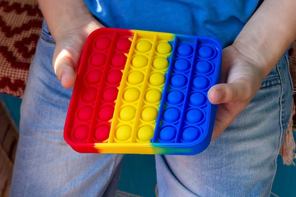 stock image Children's hands holds an antistress toy popit.