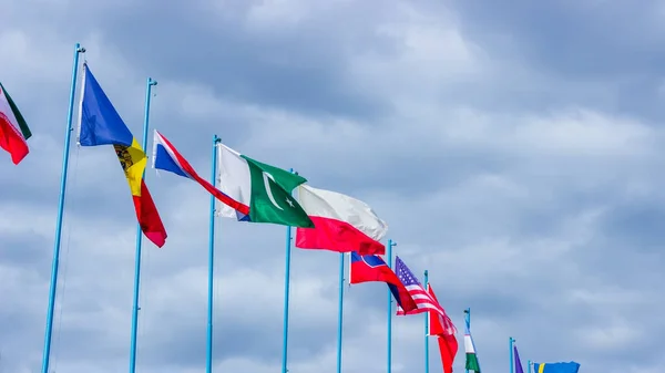 stock image Waving flags in the blue sky. Friendship of countries and peoples.