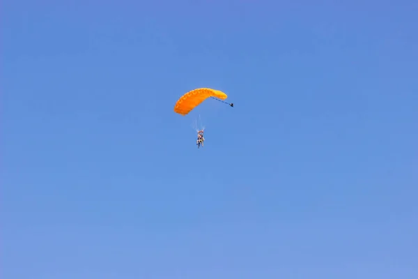 Parachutist Met Een Oranje Parachute Blauwe Lucht Stockfoto
