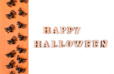 Mutlu Cadılar Bayramı yazıları. Turuncu ve beyaz arka planda. Kopyalama. Üst üste örümcekler.