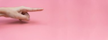 Pembe arka planda işaret parmağı olan bir kadın eli. Uzayı kopyala Pankart.